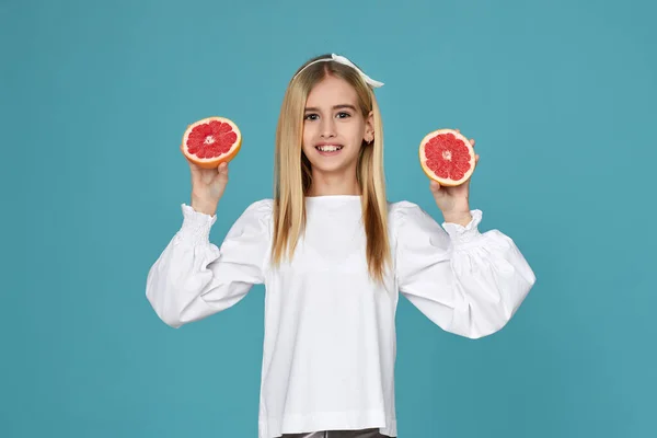 Мила маленька дівчинка тримає свіжий соковитий грейпфрут — стокове фото