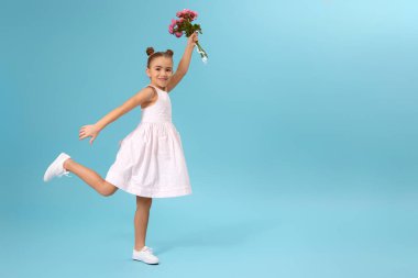 Mutlu küçük kız elinde bir buket gül tutuyor