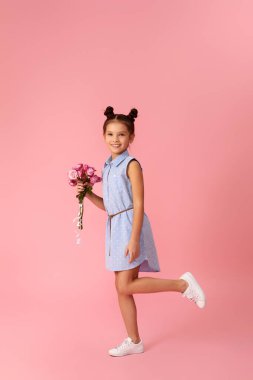 Küçük kız pembe gül buketi tutuyor
