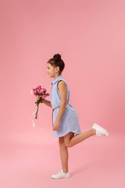 Küçük kız pembe gül buketi tutuyor