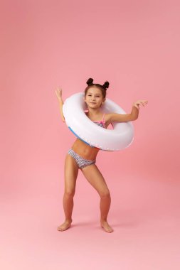 Şişirilebilir lastik çemberli mayo giyen çocuk.