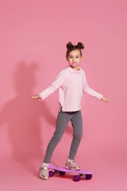 Kaykay tutan sakızlı bir kız çocuğu