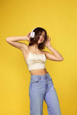 Kulaklıklı genç bir kadın müzik dinliyor.