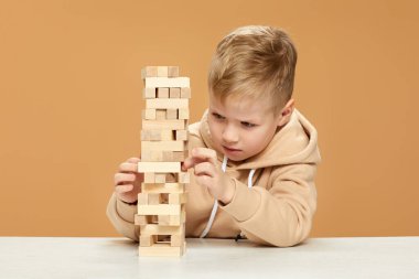 Çocuklar masa başında ahşap inşaatçıyla oynuyorlar..