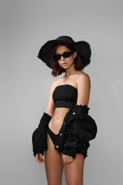 Siyah mayo ve şapkalı bronzlaşmış genç bir kadın.