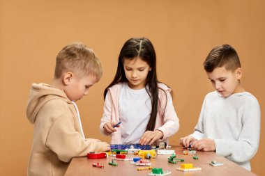 Coşkulu çocuklar stüdyoda elektronik devreler topluyor.