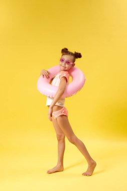 Şişirilebilir lastik yüzüklü mayo giyen çocuk.