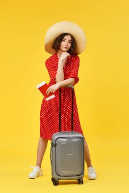 Bavullu kadın sarı arka planda seyahat ediyor..