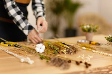 Çiçekçi çok güzel kurutulmuş çiçek buketi yapıyor.