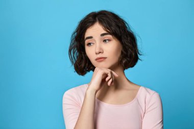 woman looking sideways with doubtful and skeptical expression.