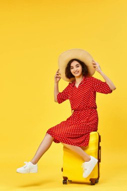 Bavullu kadın sarı arka planda seyahat ediyor..