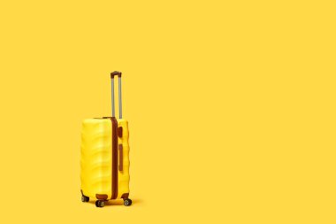 Sarı arka planda seyahat valizi. metin için boşluk kopyala