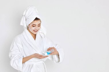 Kadın elleri makyaj malzemelerini temizlemek için pamuk çubuğu ve tonik tutuyor..