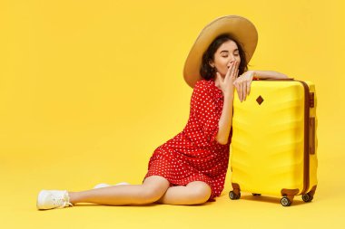 Bavullu kadın sarı arka planda seyahat ediyor..