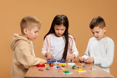 Coşkulu çocuklar stüdyoda elektronik devreler topluyor.