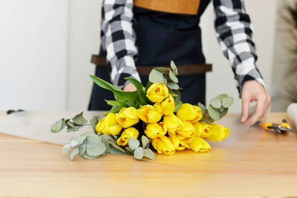 Florist macht einen Strauß frischer gelber Tulpen. — Stockfoto