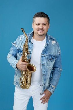 Stüdyo arka planında saksafonu olan müzisyen..