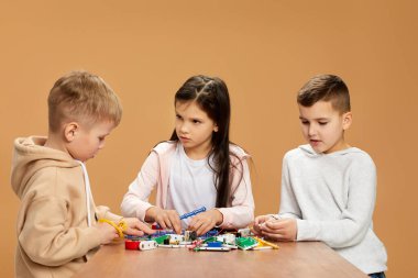 Coşkulu çocuklar stüdyoda elektronik devreler topluyor.