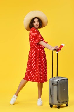 Bavullu kadın sarı arka planda seyahat ediyor..