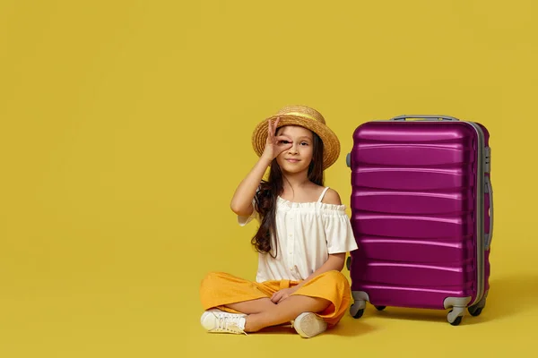 Niña con maleta y pasaporte sentada en el suelo — Foto de Stock