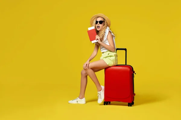 Mädchen mit Hut, Pass und Ticket sitzt auf rotem Koffer — Stockfoto