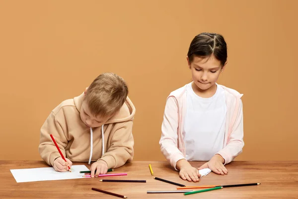 Boldog gyerekek rajzolnak együtt az asztalnál — Stock Fotó
