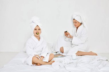 Küçük kız elinde salatalık dilimleri ve elinde tırnak törpüsü tutuyor.