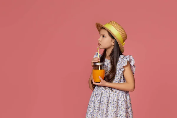 Мила маленька дівчинка в капелюсі з апельсиновим соком — стокове фото