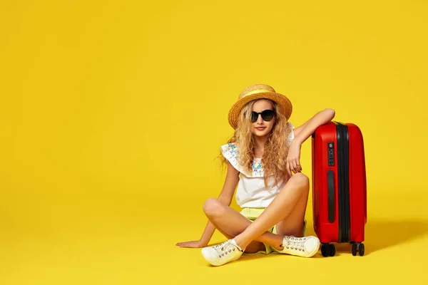 Збуджена маленька дівчинка з валізою і паспортом сидить на підлозі — стокове фото