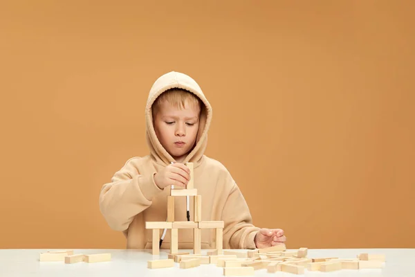 Niños juegan con constructor de madera en el escritorio. — Foto de Stock