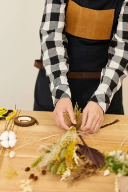 Çiçekçi çok güzel kurutulmuş çiçek buketi yapıyor.