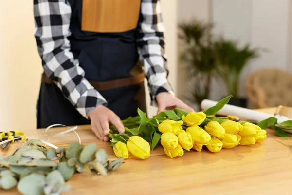 Virágos nő csinál egy csokor friss sárga tulipán. — Stock Fotó