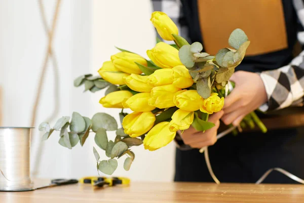 Virágos csinál egy csokor friss sárga tulipán. — Stock Fotó