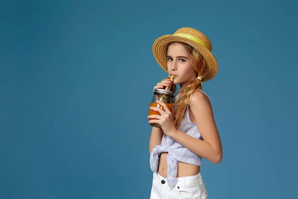 Портрет милої маленької дівчинки, яка п'є апельсиновий сік — стокове фото