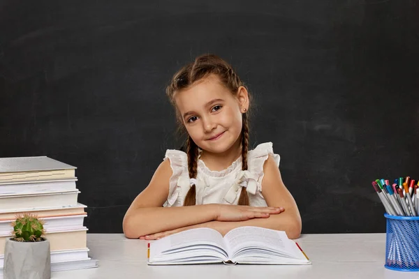 Маленькая девочка читает книгу в классе — стоковое фото