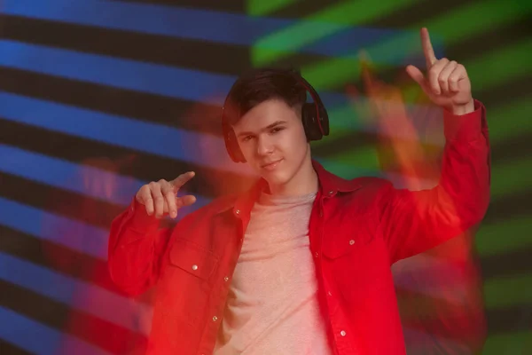 Νεαρός άνδρας με κόκκινο πουκάμισο με ακουστικά ακούγοντας μουσική — Φωτογραφία Αρχείου