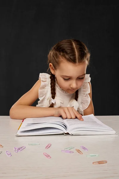 Menina criança lendo um livro na sala de aula — Fotografia de Stock
