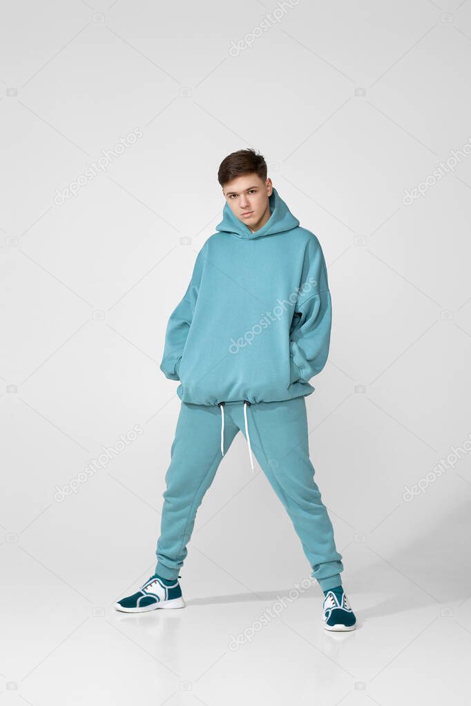 Handsome guy wearing stylish blank hoodie or sweatshirt with space for logo or design. Mock up for design