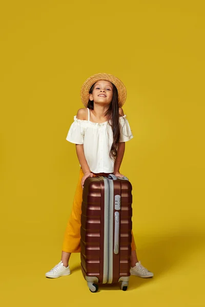 Happy little girl dziecko w kapeluszu z różową walizką — Zdjęcie stockowe