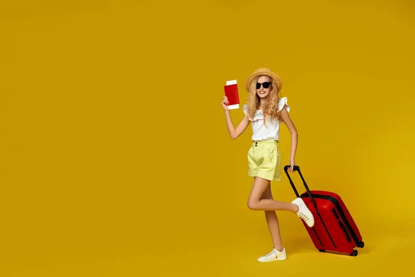 Дівчина з червоною валізою і паспортом з квитком подорожує — стокове фото
