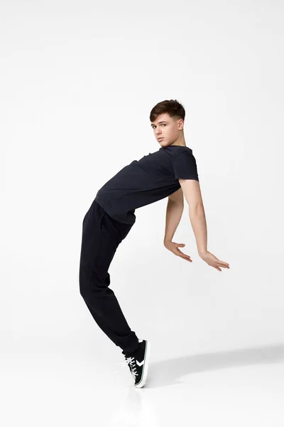 검은 티셔츠 점프를 하는 잘생긴 청년. — 스톡 사진
