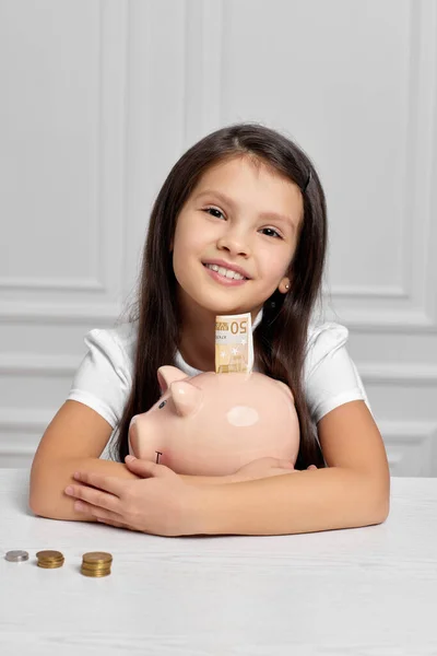 Menina criança com banco porquinho em casa — Fotografia de Stock