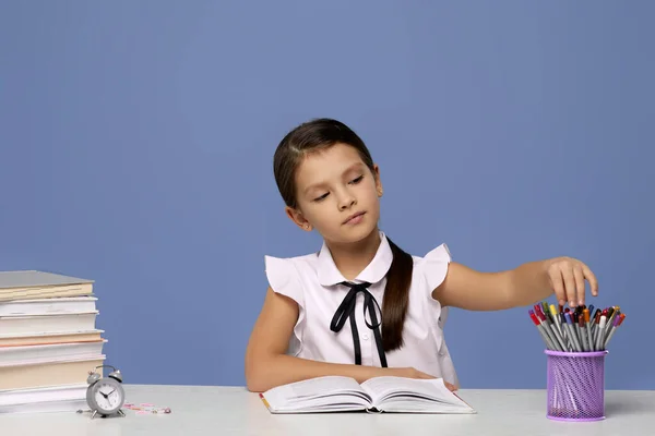 Boldog iskoláslány tanul egy halom könyvvel — Stock Fotó