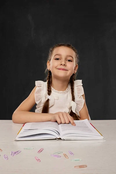 Klein kind meisje het lezen van een boek in de klas — Stockfoto