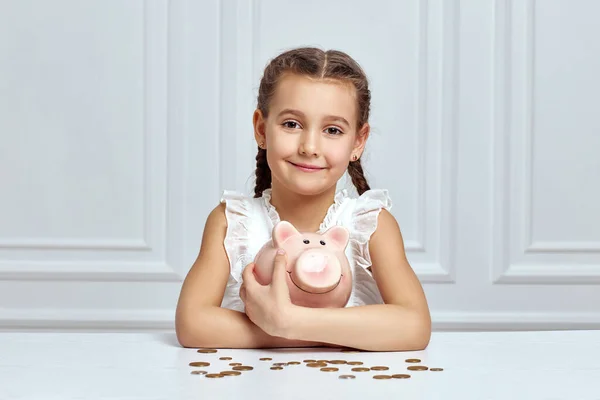 Little child girl with piggy bank at home — Stock Photo, Image