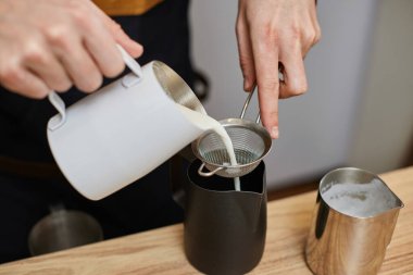 Kafkasyalı bir adam kahveye sıcak süt dolduruyor..