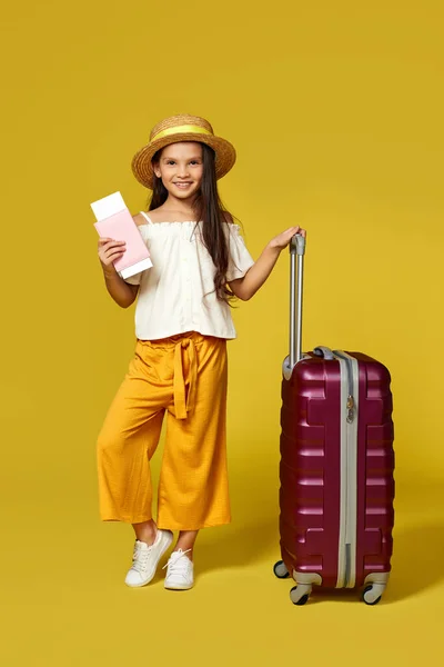 Glückliches kleines Mädchen mit Hut und rosa Koffer — Stockfoto