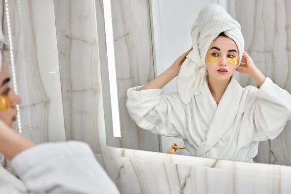 Hermosa mujer con parches para los ojos en albornoces blancos en el baño — Foto de Stock