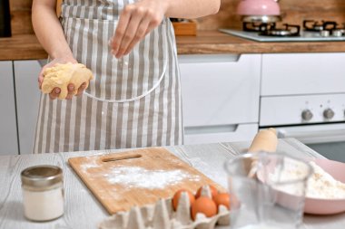 Ev hanımı evde mutfakta yemek pişiriyor..