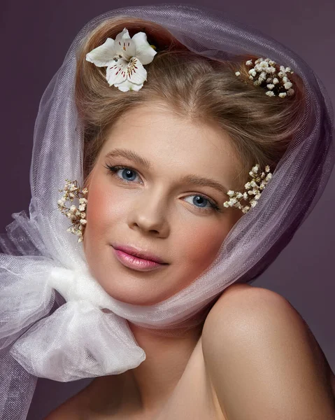 Blonde vrouw met roze make-up en bloemen in het haar — Stockfoto